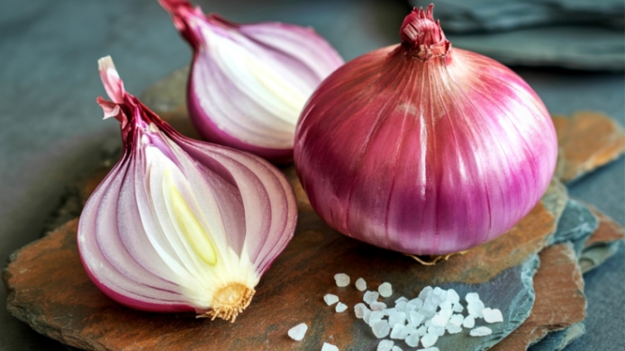 cebolla roja sobre tabla de cortar